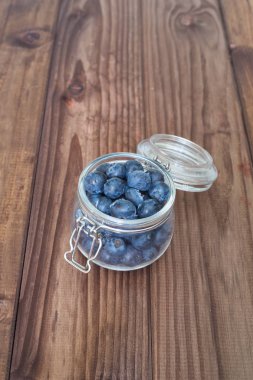 Ahşap bir masa üzerinde bir kavanoza yaban mersini / yeri yazıt için