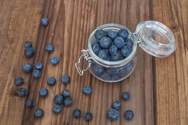 Ahşap bir masa üzerinde bir kavanoza yaban mersini