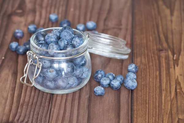 Ahşap bir masa üzerinde bir kavanoza yaban mersini