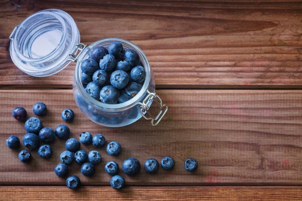Ahşap bir masa üzerinde bir kavanoza yaban mersini / yeri yazıt için