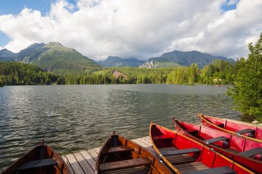 Panorama mountain lake Strbske Pleso Tatra Dağları'nda. Summers'ın günbatımı renkleri ve yüzme için tekne