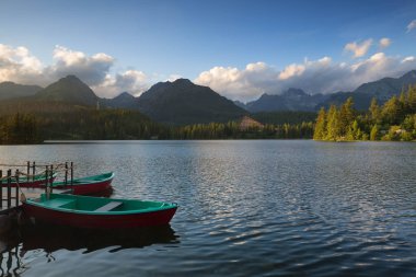 Panorama mountain lake Strbske Pleso Tatra Dağları'nda. Yaz günbatımı renkleri ve yüzme için tekne