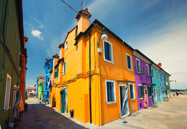 The colorful architecture of the sunny Island of Burano, a tourist attraction near Venice, Italy, which shows the harmony, joyful approach and lifestyle
