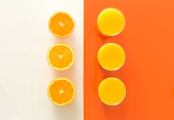 Апельсиновий сік і фрукти на оранжево-білому склі — стокове фото