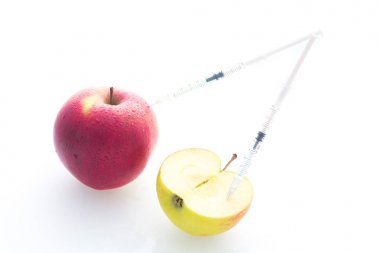 Delikli iğne ve şırınga ile elma yemek değiştirmek için bir kavram olarak / beyaz arka plan