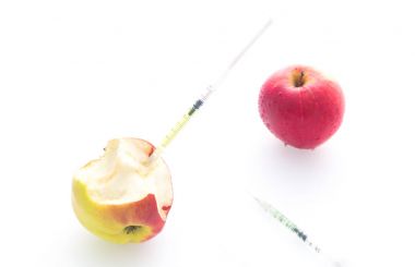 Delikli iğne ve şırınga ile elma yemek değiştirmek için bir kavram olarak / beyaz arka plan