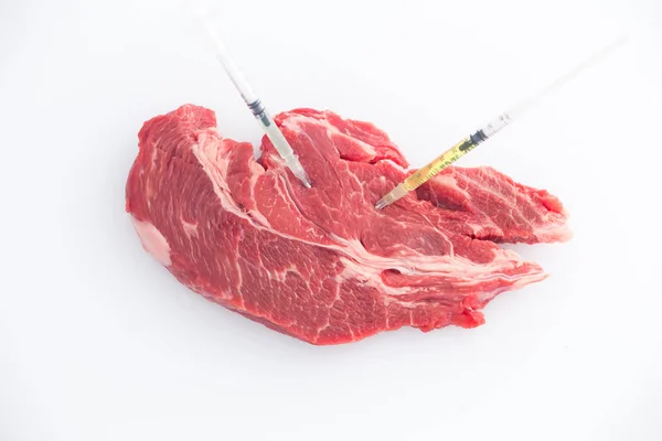 Gemodificeerde levensmiddelen. Rundvlees van vlees met ingesloten spuiten / concept — Stockfoto