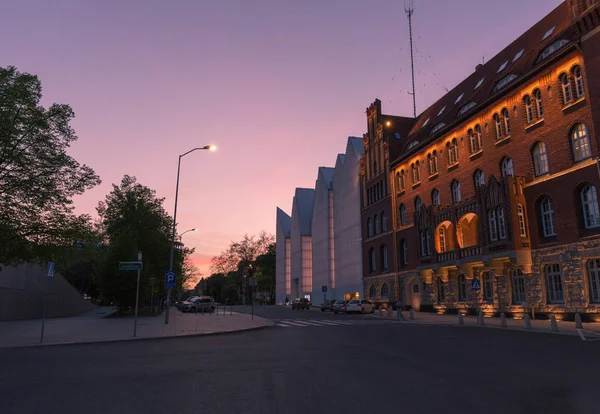 Szczecin. the sun setting over the city buildings in the city center