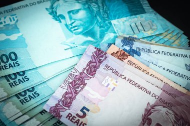 Brezilya parası işte. Masanın üzerinde banknotlar var.
