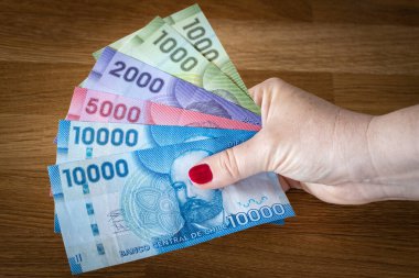 Şili pesoları, banknotlar bir kadının elinde.