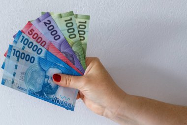 Şili pesoları, banknotlar bir kadının elinde.