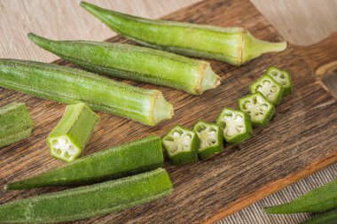 Bamya. Mutfak tahtasında sebze, kısmen doğranmış.