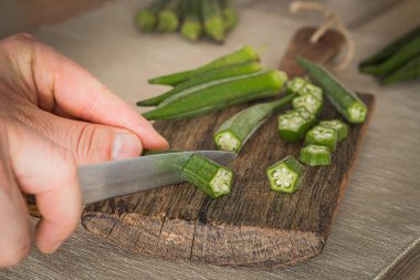 Okra. Vegeteble on a kitchen board, partly chopped clipart