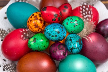 Ahşap bir masaya farklı renkte yumurta boyamak, Paskalya süslemesi.,