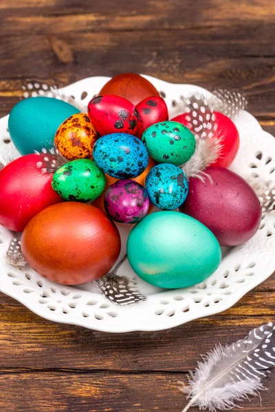 painted eggs of different colors on a wooden table, Easter decoration