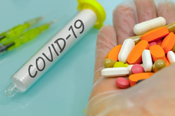 Covid-19 in einem Fläschchen, Hand in Gummihandschuh mit Medikamenten und Injektionen. Konzept zur Arbeit an einem Virusimpfstoff — Stockfoto