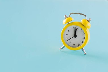 Mavi bardakta küçük sarı bir çalar saat. Metin için yer