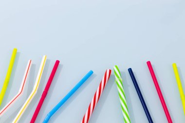 Renkli plastik, mavi bardakta pipet içiyor. Plastik Dünya 'yı sel baskını konsepti. Metin için boşluk