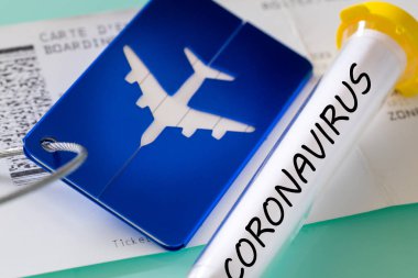 Coronavirus. Laboratuvar şişesi, biniş kartı ve bagaj etiketi. Virüsten dolayı havayolu finansal sorunları kavramı
