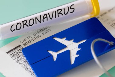 Coronavirus. Laboratuvar şişesi, biniş kartı ve bagaj etiketi. Virüsten dolayı havayolu finansal sorunları kavramı
