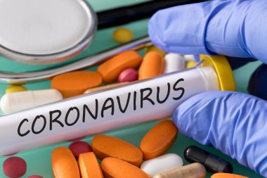 Coronavirus şişesi ve tıbbi bir eldivende bulunan çeşitli ilaçlar, arka planda stetoskop. Tehlikeli bir virüsle enfekte olmuş insanları tedavi etme ve ilaç arama kavramı