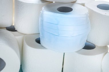 Anti virüs maskesi içinde tuvalet kağıdı rulosu. Coronavirus salgını sırasında mal satın almanın sembolü
