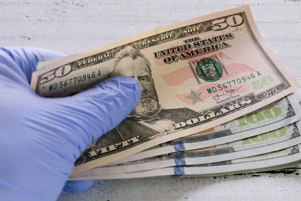 Lastik eldivenlerde Amerikan doları var. Coronavirus salgını sırasında ekonomik ve mali tehditler kavramı