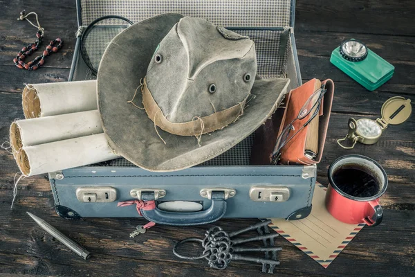 准备旅行 把手提箱收拾好冒险的概念 复古风格 旧地图 手提箱 笔记本 放大镜 手电筒 组合帽 指南针 — 图库照片