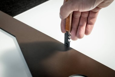  Bir işçi cam atölyesinde cam kesiyor. 