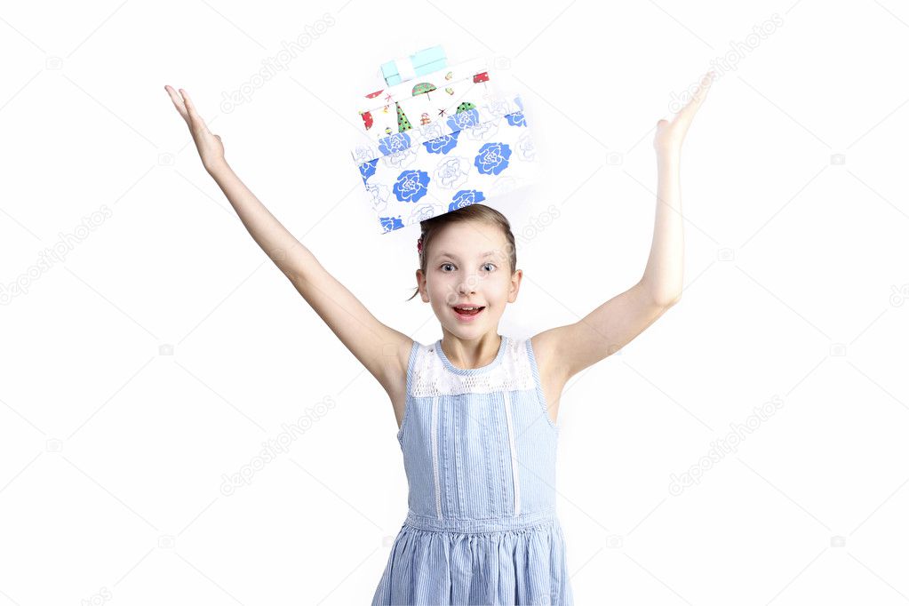 the portrait of young little girl with present boxes on head holding hands-up over white background