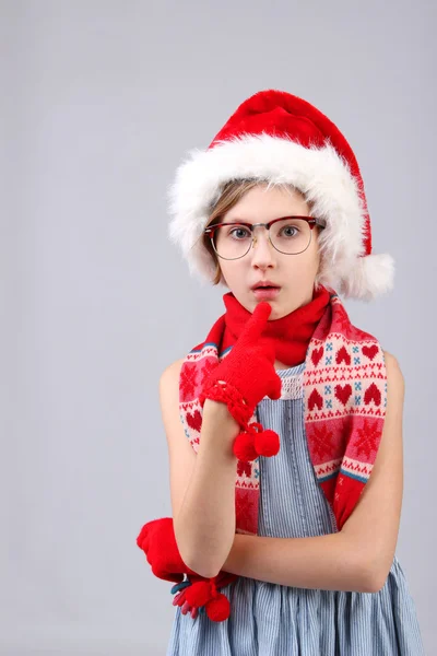 Detailní portrét malé holčičky v Santa pomocník klobouk a brýle přes světlé pozadí — Stock fotografie