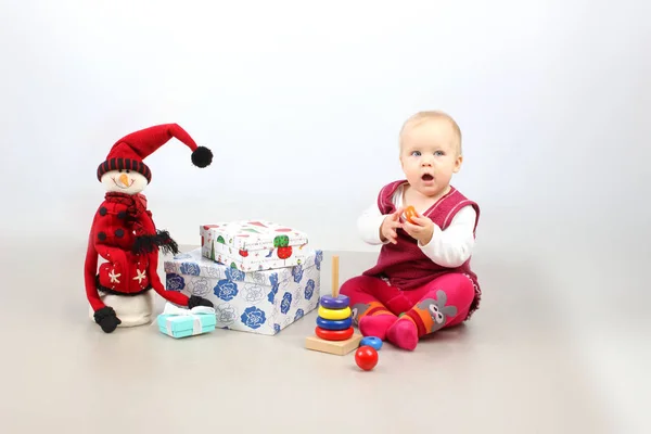 Estúdio tiro de sentado adorável bebê menina em vestido vermelho abertura presentes de Natal . — Fotografia de Stock