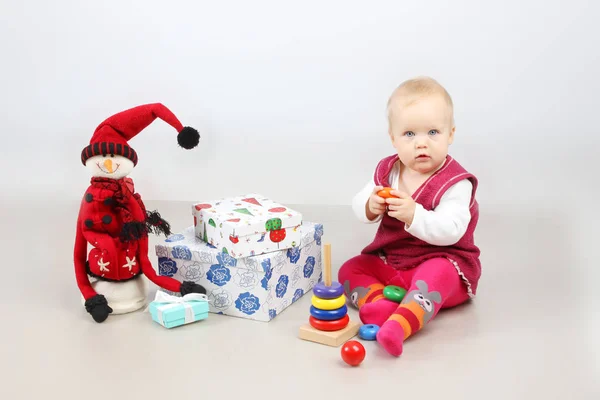 . Estúdio tiro de sentado adorável bebê menina em vestido vermelho abertura presentes de Natal . — Fotografia de Stock