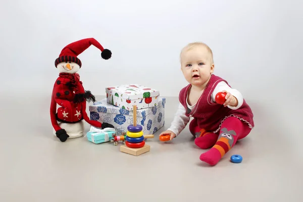 Adorável bebê menina em vestido vermelho abrindo presentes de Natal . — Fotografia de Stock