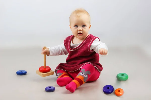 Adorable petite fille en vêtements rouges jouant avec des jouets . — Photo