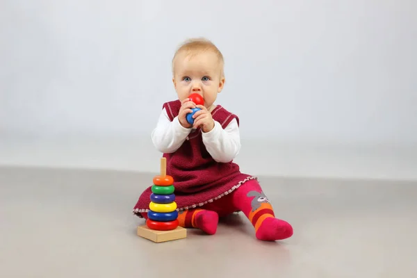 Adorable petite fille en vêtements rouges jouant avec des jouets . — Photo