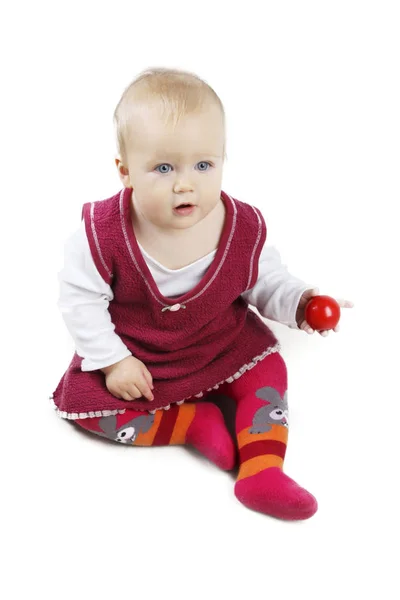 Siedzi urocza mała dziewczynka w czerwonej sukience - na białym tle nad białym tle. — Zdjęcie stockowe