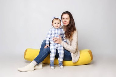  Bir anne oğluyla birlikte oturan stüdyo çekim.