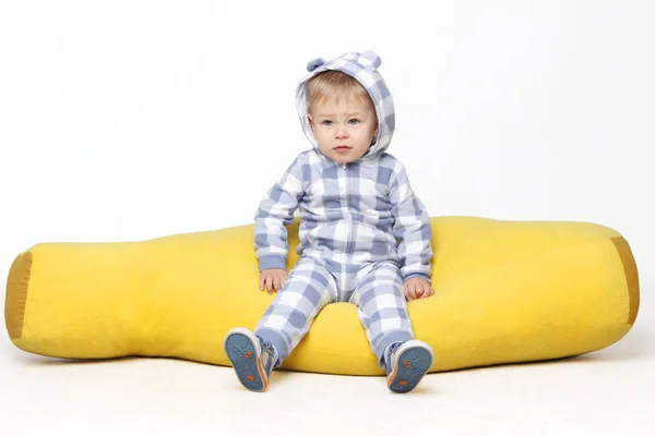 Porträt eines entzückenden Jungen, der auf dem gelben Bohnensack sitzt. — Stockfoto
