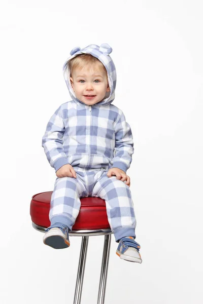 Lövés egy imádnivaló baba fiú ül a vörös szék. — Stock Fotó