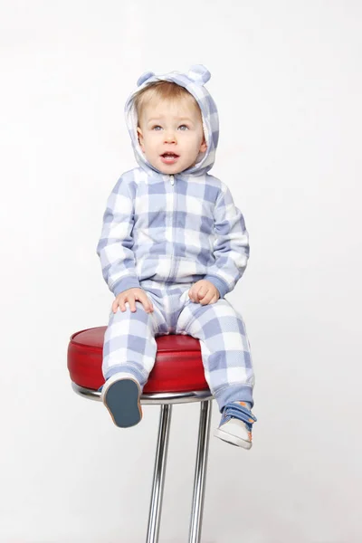 Adorable baby boy sitting on the red chair — Stock Photo, Image