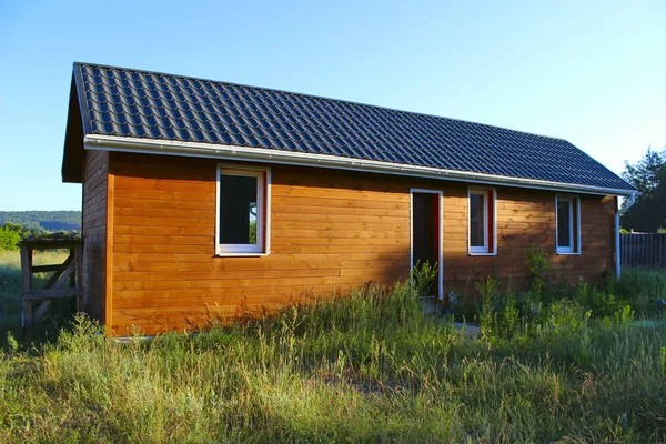 Casa de madera con prado frente a ella . — Foto de Stock