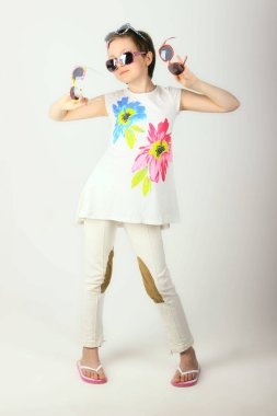 Güneş gözlüğü ile oynayan sevimli küçük kız.