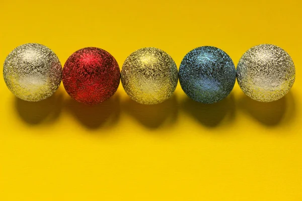 Χρωματιστή μπάλα διακοσμήσεων Χριστουγέννων σε κίτρινο φόντο με χώρο για κείμενο. — Φωτογραφία Αρχείου