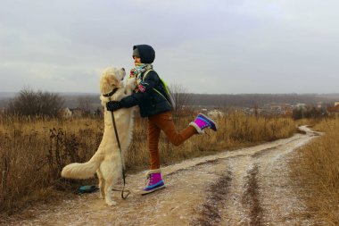 İnsanlar, Evcil Hayvan, çocuk kavramı. Şirin kız onu evde beslenen hayvan Golden Retriever ile yürüyüş. Genç Kız köpekle oynamayı. 