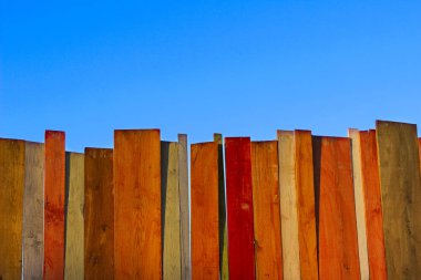 Çok renkli ahşap duvar ve mavi gökyüzü. Renkli duvar ahşap kopya alan bir sürü ile. Ahşap çit ve mavi gökyüzü. Renkli boyalı eski püskü ahşap Resepsiyon arka. Ahşap arka plan.