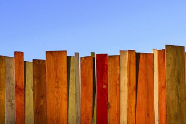 Çok renkli ahşap duvar ve mavi gökyüzü. Renkli duvar ahşap kopya alan bir sürü ile. Ahşap çit ve mavi gökyüzü. Renkli boyalı eski püskü ahşap Resepsiyon arka. Ahşap arka plan.