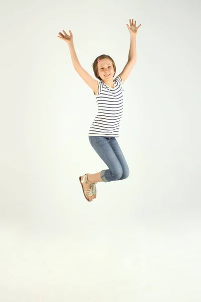 垂直跳跃的小女孩肖像 可爱跳跃的女孩 开朗漂亮的年轻女孩跳和手举起手来 — 图库照片