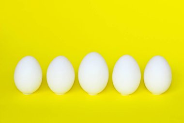 Gıda maddeleri, Kahvaltı, Paskalya kavramı. Sarı Background.Minimal sanat tasarım üzerinde beyaz tavuk yumurtası. Yumurta Sarı zemin üzerinde. Arka plan.