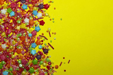 Renkli arka plan. Kopya alanı için Text.Many çok renkli bir sürü sarı arka plan üzerinde renkli şeker şeker sarı Background.Closeup çok renkli küçük şeker, tatlılar.